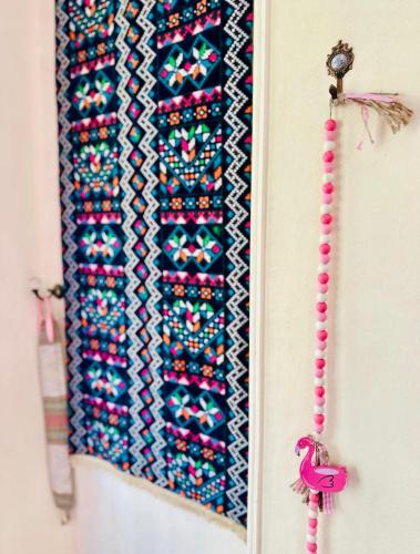 a mirror hanging on a wall with a pink bookmark at BlueHostel in Cairo