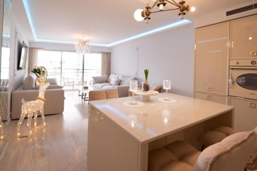 une cuisine et un salon avec une table et des chaises dans l'établissement 2-bedroom luxurious apartment with balcony and parking, à Cannes