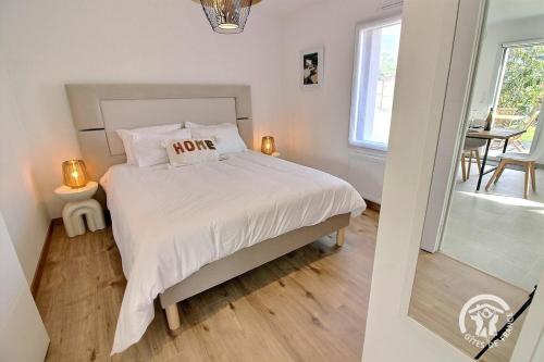 une chambre avec un lit avec des draps blancs et une fenêtre dans l'établissement house for 2 with private jacuzzi - Emerald, à Lancieux