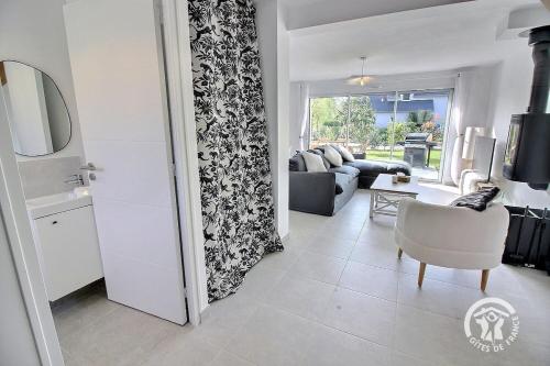 - un salon avec un canapé, une chaise et une porte dans l'établissement house for 2 with private jacuzzi - Emerald, à Lancieux