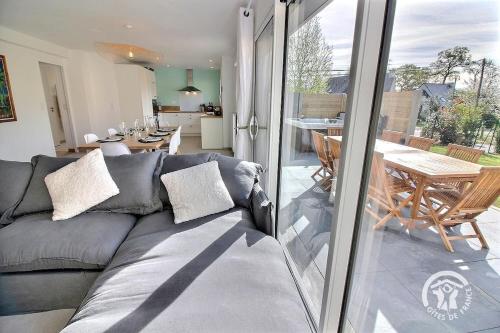 - un salon avec un canapé gris et une salle à manger dans l'établissement house for 2 with private jacuzzi - Emerald, à Lancieux