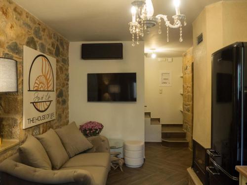 a living room with a couch and a tv at The House of Life in Pírgos