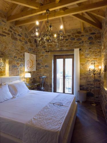 a bedroom with a large bed in a stone wall at The House of Life in Pírgos
