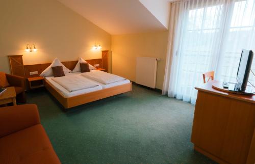 a hotel room with a bed and a television at Gästehaus Kraft in Lauffen am Neckar