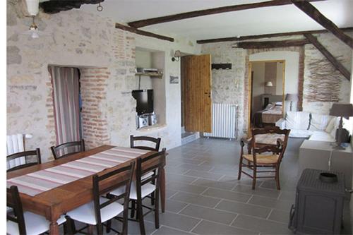 a dining room with a table and chairs and a bedroom at Maison Narbay 2 p in Saint-André-de-Seignanx