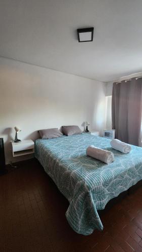 a bedroom with a bed with two pillows on it at Departamento Pedernera in Godoy Cruz