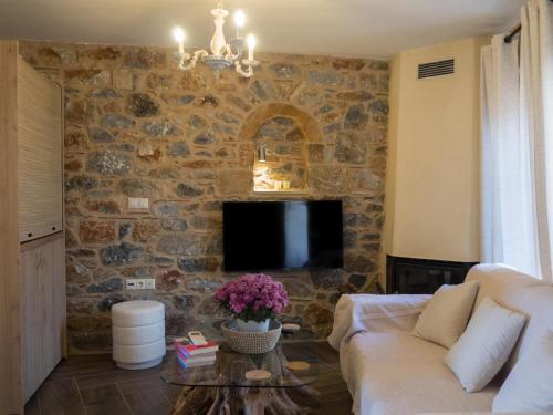 a living room with a couch and a stone wall at The House of Life in Pírgos