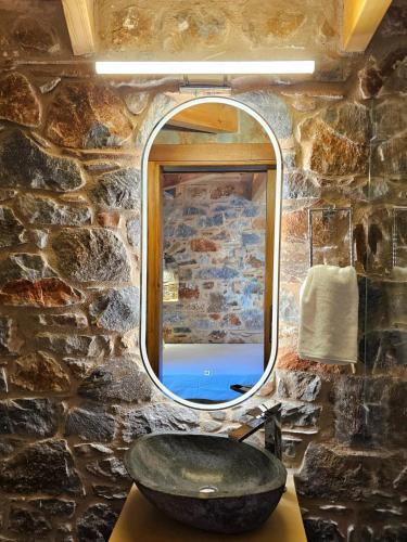 a stone bathroom with a sink and a mirror at The House of Life in Pírgos