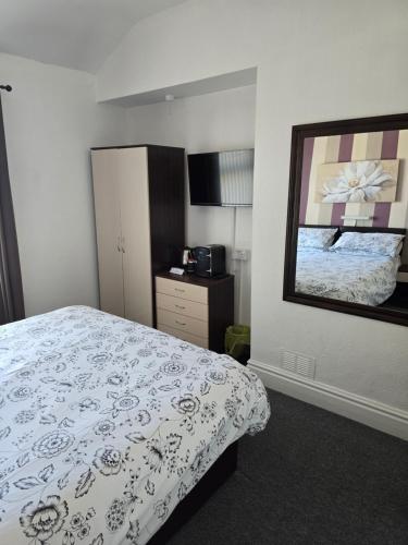 a bedroom with a bed and a dresser in it at Langroyd Hotel in Blackpool