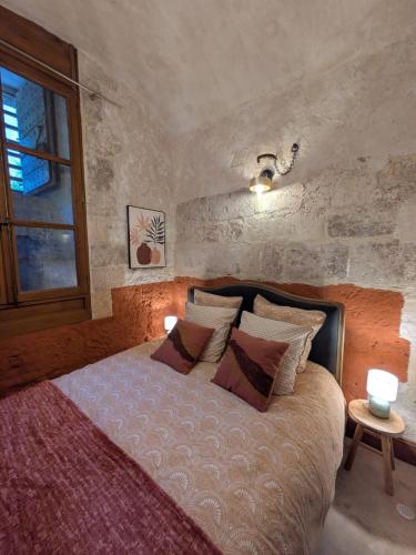 une chambre avec un lit avec des oreillers et une fenêtre dans l'établissement Le Donjon Beauvoir - appartement insolite au centre de Blois, à Blois