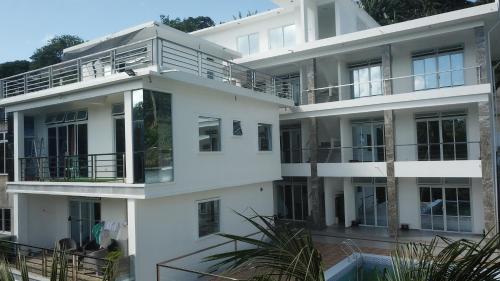 a white apartment building with a pool in front of it at Palma Resort in Puerto Galera