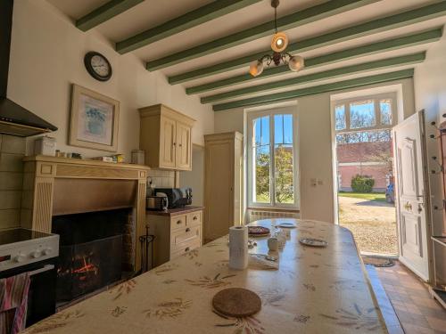 - une cuisine avec une table et une cheminée dans l'établissement Moulin paisible en Berry avec étang privé, proche du Château de Valençay et Zoo de Beauval - FR-1-591-18, à Chabris