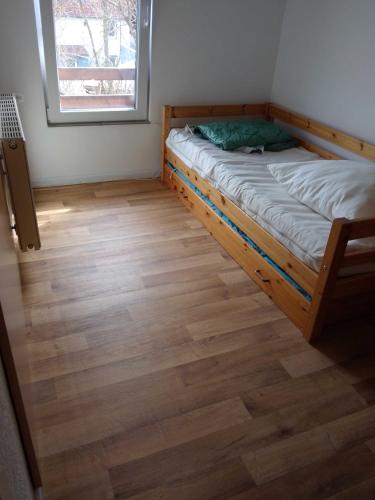a bedroom with a bed and a wooden floor at Harz meets friends in Hasselfelde