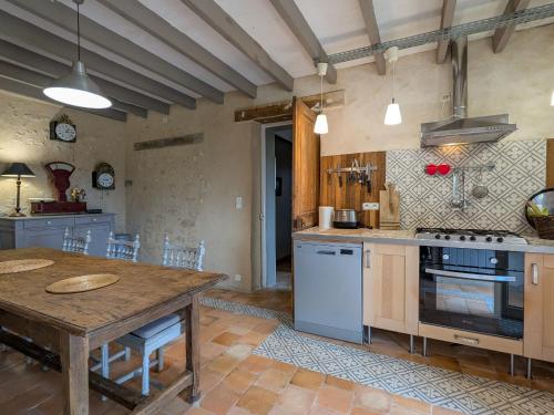 une grande cuisine avec une table en bois et une table et une table dans l'établissement Gîte en Berry au cœur du Parc Naturel avec jardin et parking, 3 chambres, cheminée - FR-1-591-157, à Mézières-en-Brenne