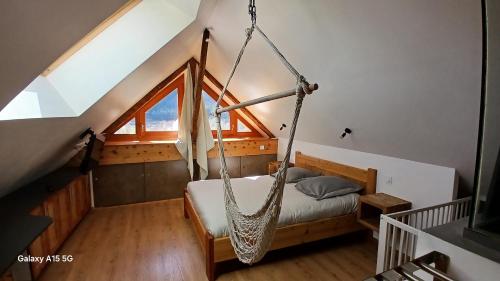 - une chambre avec un hamac suspendu au toit dans l'établissement Maison de village, à La Roche-de-Rame