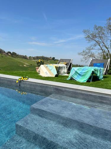 a swimming pool with tents next to a field at Casa Sunset Hill Bologna in Bologna