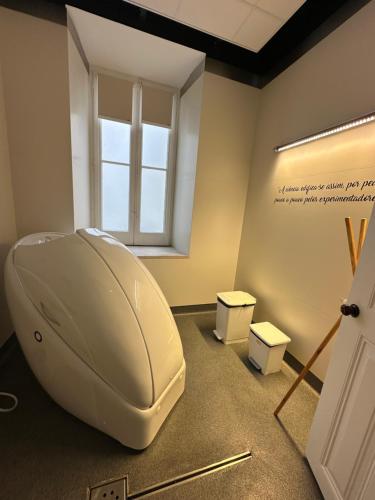 a bathroom with a toilet in a room with a window at 19 Tile Ceramic Concept - by Unlock Hotels in Caldas da Rainha