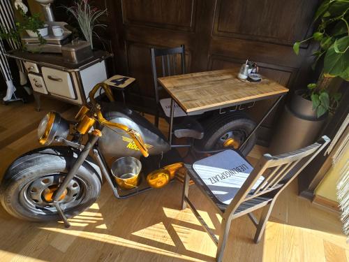 a motorcycle parked next to a table and a chair at Hotel Grenzenlos im Alten Gut in Würzburg