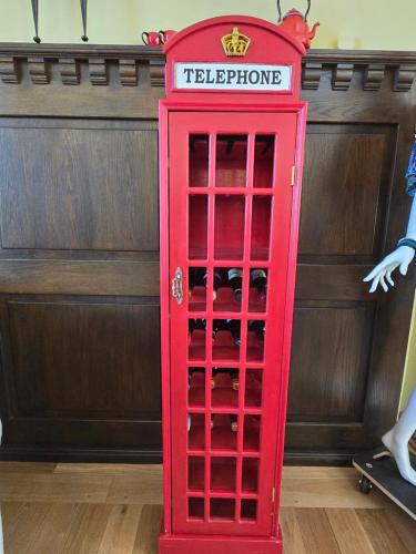 a red telephone booth in front of a wall at Hotel Grenzenlos im Alten Gut in Würzburg