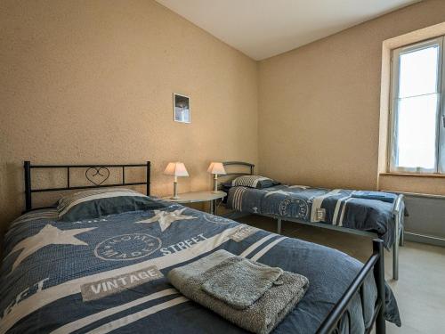 a bedroom with two beds and a window at Gîte en Brenne avec Terrasse et Garage Privé - FR-1-591-316 in Migné