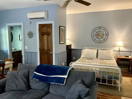 a living room with a couch and a bed at Secluded Woodland Cabin Rental with Hot Tub in Yadkin Valley Wine Region in Elkin