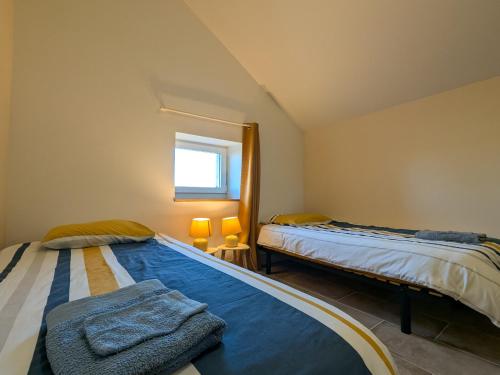 una camera da letto con due letti e una finestra di Gîte au cœur du Parc de la Brenne avec jardin, terrasse et parking - FR-1-591-317 a Migné