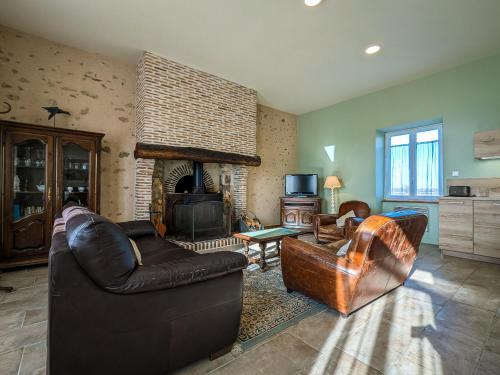 un salon avec un canapé et une cheminée dans l'établissement Gîte au cœur du Parc de la Brenne avec jardin, terrasse et parking - FR-1-591-317, à Migné