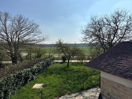 a view of a yard with trees and a building at Chambre dans une Ecurie in Avilly-Saint-Léonard