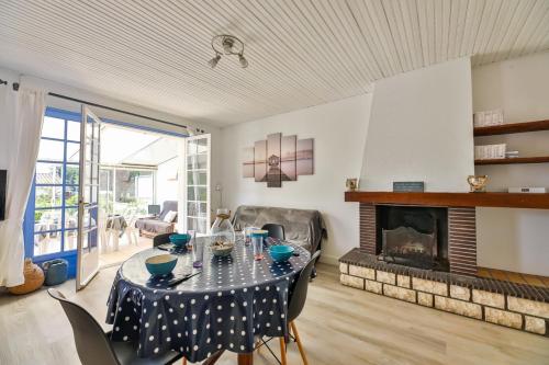 a living room with a table and a fireplace at Le Temps de Vivre - Maison & dépendance in Notre-Dame-de-Monts