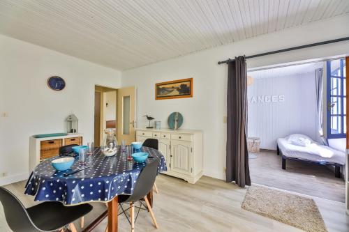 a dining room with a table and chairs at Le Temps de Vivre - Maison & dépendance in Notre-Dame-de-Monts