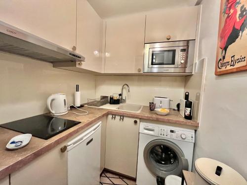 une petite cuisine avec un évier et une machine à laver dans l'établissement Rouaze by Welcome to Cannes, à Cannes