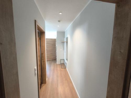 a hallway with white walls and a wooden floor at Birkhofer See genießen - Aparthotel am Bodensee in Immenstaad am Bodensee