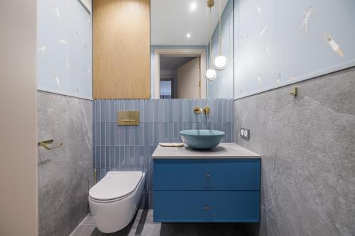a bathroom with a blue sink and a toilet at Rezydencja Merwede Aparthotel - My Rest in Gdańsk