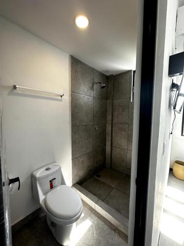 a bathroom with a toilet and a shower at Punta Conejo Camila bungalows Surf Camp in Reparo