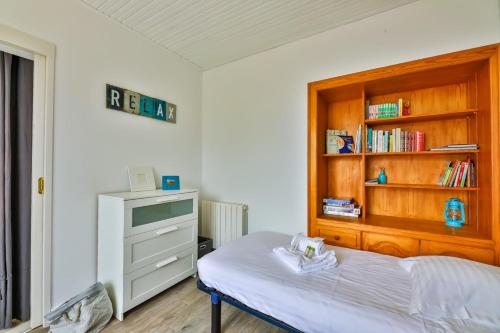 a bedroom with a bed and a book shelf at Le Temps de Vivre - Maison & dépendance in Notre-Dame-de-Monts