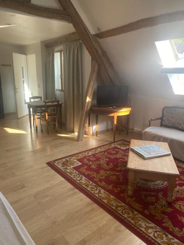 a living room with a couch and a table at Grand studio lumineux à 10 min de Compiègne in Baugy