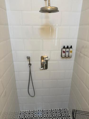 a white tiled shower with a shower head at Mulberry House Farm Mulberry Lodge in Chippenham