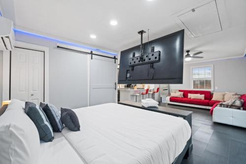 una camera con un letto bianco e un divano rosso di Splash Pad by Book That Condo a Panama City Beach