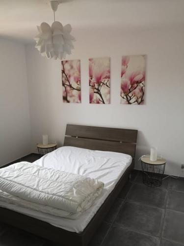 une chambre avec un lit et deux tableaux au mur dans l'établissement Villa familiale piscine Bandol, à Bandol