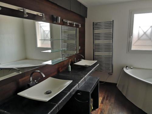 une salle de bain avec deux lavabos et une baignoire dans l'établissement Villa familiale piscine Bandol, à Bandol