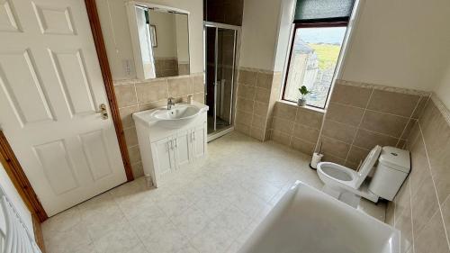 a bathroom with a sink and a toilet at Harbour Views 3 Bed Townhouse with private off street parking and office in Portstewart