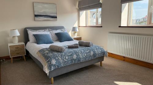 a bedroom with a large bed with blue pillows at Harbour Views 3 Bed Townhouse with private off street parking and office in Portstewart