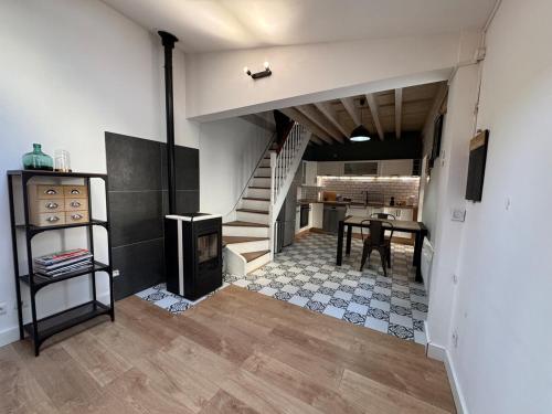une pièce avec un escalier et une table et une cuisine dans l'établissement Belle maison chaleureuse dans le centre de Brindas, à Brindas