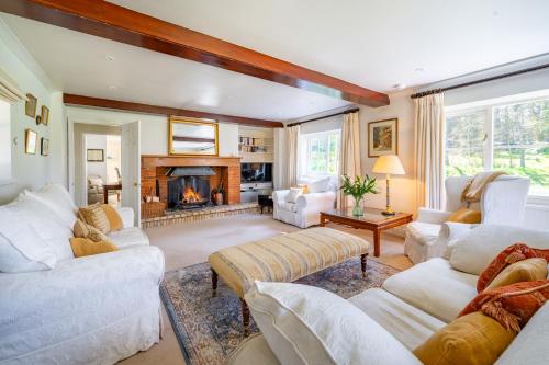 a living room with white furniture and a fireplace at Marvellous secluded forest lodge - Stone Hall in Eyke