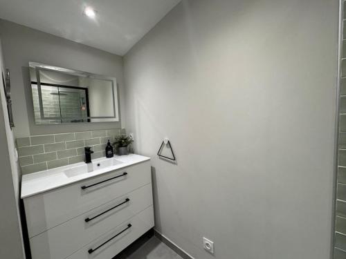 a bathroom with a white sink and a mirror at Belle maison chaleureuse dans le centre de Brindas in Brindas
