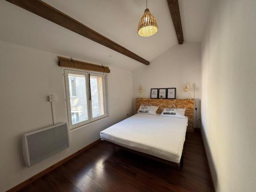 a bedroom with a bed and a television in it at Belle maison chaleureuse dans le centre de Brindas in Brindas