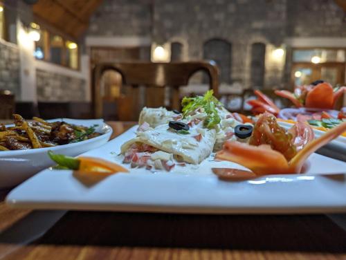 a plate of food on a table with plates of food at Destination Hotel Khaplu in Khaplu