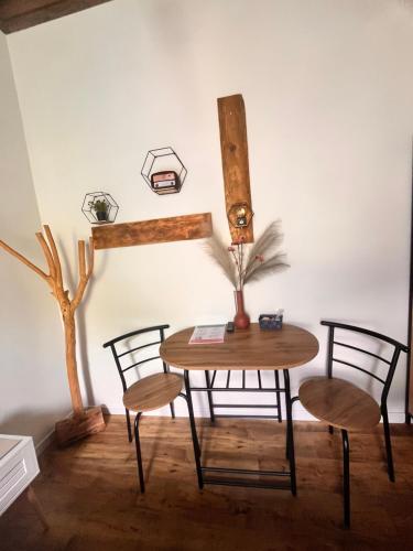 a table and chairs in a room with a wall at Stanza in sondrio Coel in Sondrio