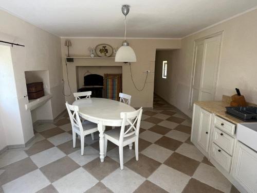 une cuisine avec une table et des chaises dans une pièce dans l'établissement Petite maison à côté d'Argenton-sur-Creuse, à Vigoux