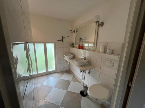 une salle de bain avec deux lavabos et une douche en verre dans l'établissement Petite maison à côté d'Argenton-sur-Creuse, à Vigoux